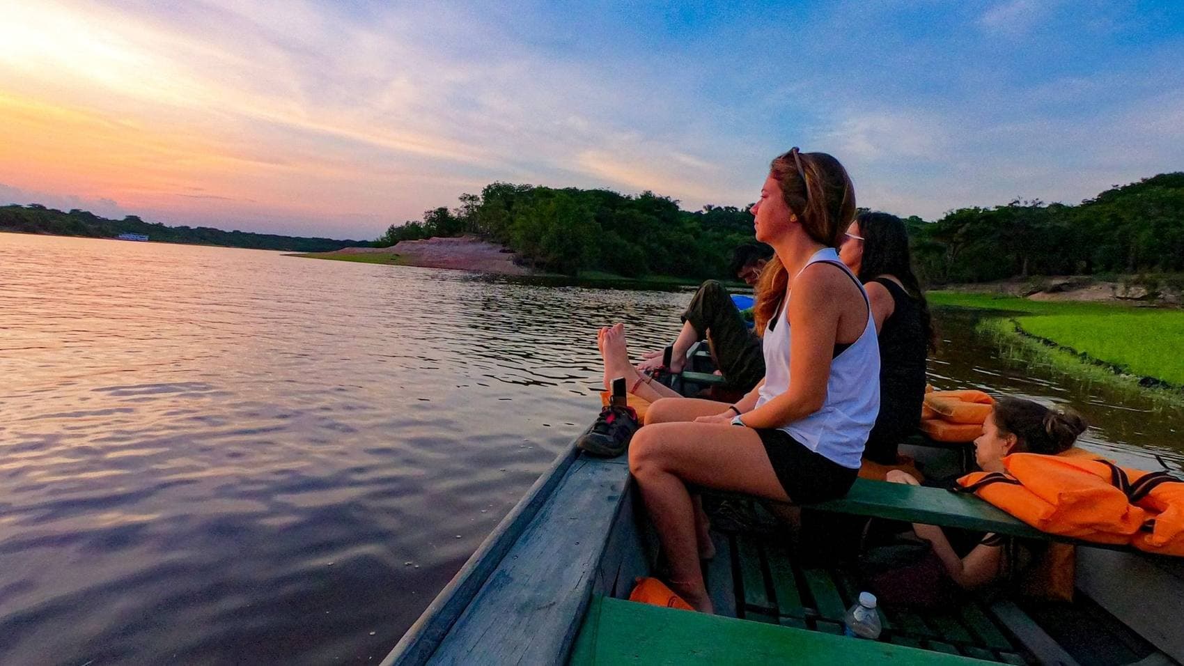 Grupo num barco ao entardecer, na Amazônia