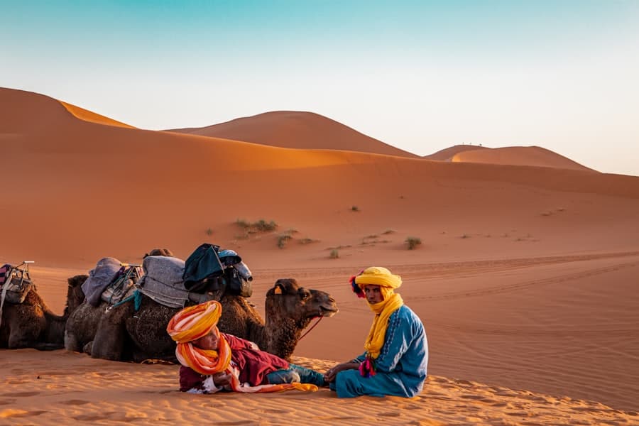 Viajantes descansando nas dunas do Marrocos