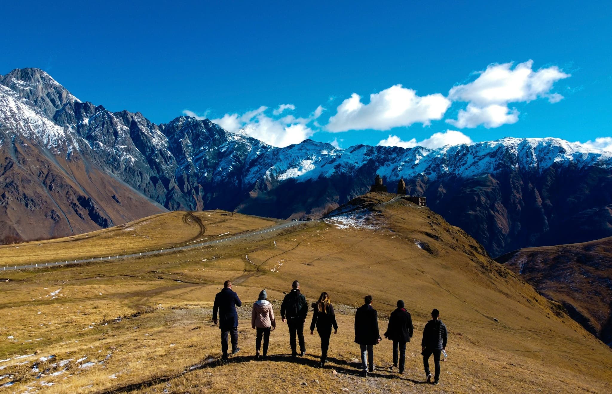 Grupo caminhando por uma paisagem de montanha durante uma jornada